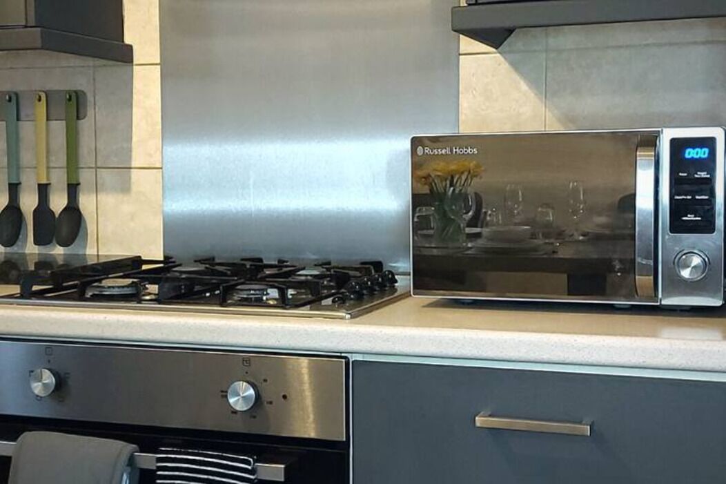 A modern kitchen with a built-in microwave, gas stove, and stainless steel appliances.