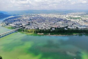 Vista aérea de una ciudad con un río, un puente y una zona urbana densa.