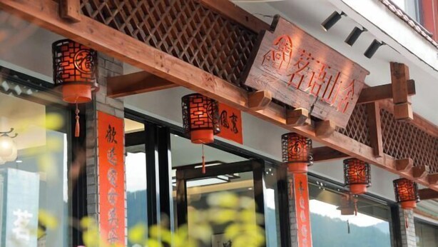 A traditional wooden structure with lanterns and Chinese characters. - Mingyu Shanshe Hostel (Wuyishan)