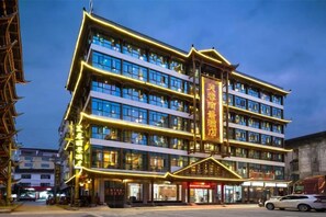 A multi-story hotel with a traditional architectural style, featuring a prominent entrance and multiple windows. - Furong Lijing Hotel (Yongshun)