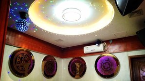 A room with a circular ceiling light, air conditioning unit, and decorative plates on the wall.