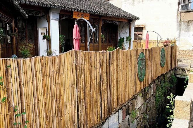 Il s’agit d’un bâtiment traditionnel doté d’une clôture en bambou, de portes en bois et d’un toit en tuiles.