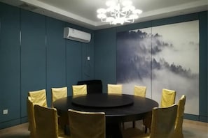 Una sala de conferencias con una mesa redonda, sillas y un aire acondicionado instalado en la pared.