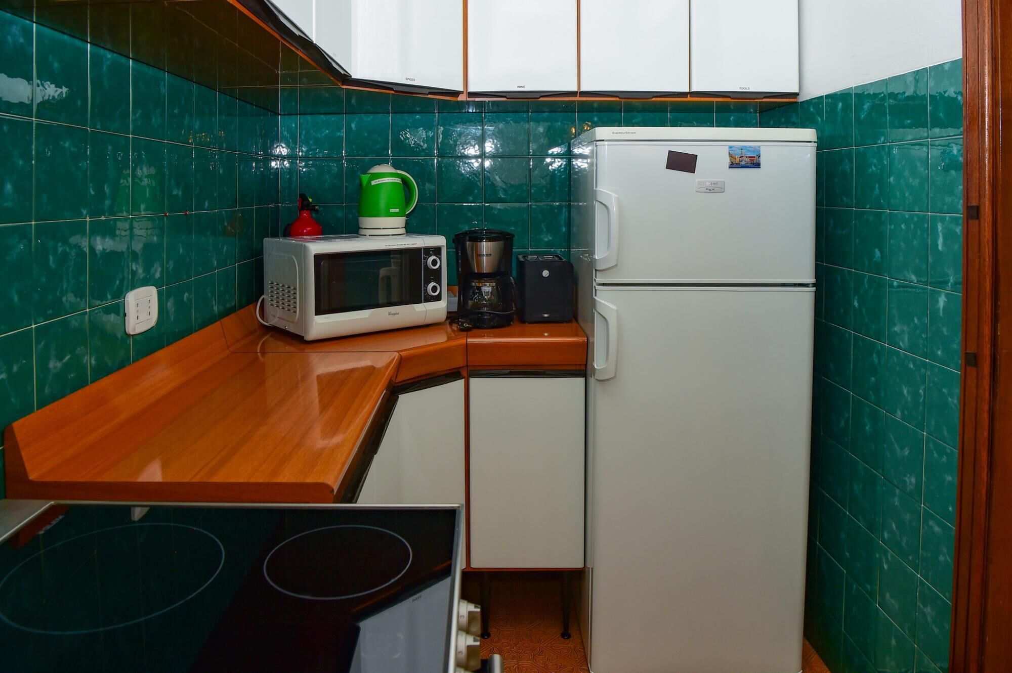 Uma cozinha compacta equipada com micro-ondas, torradeira e mini refrigerador.