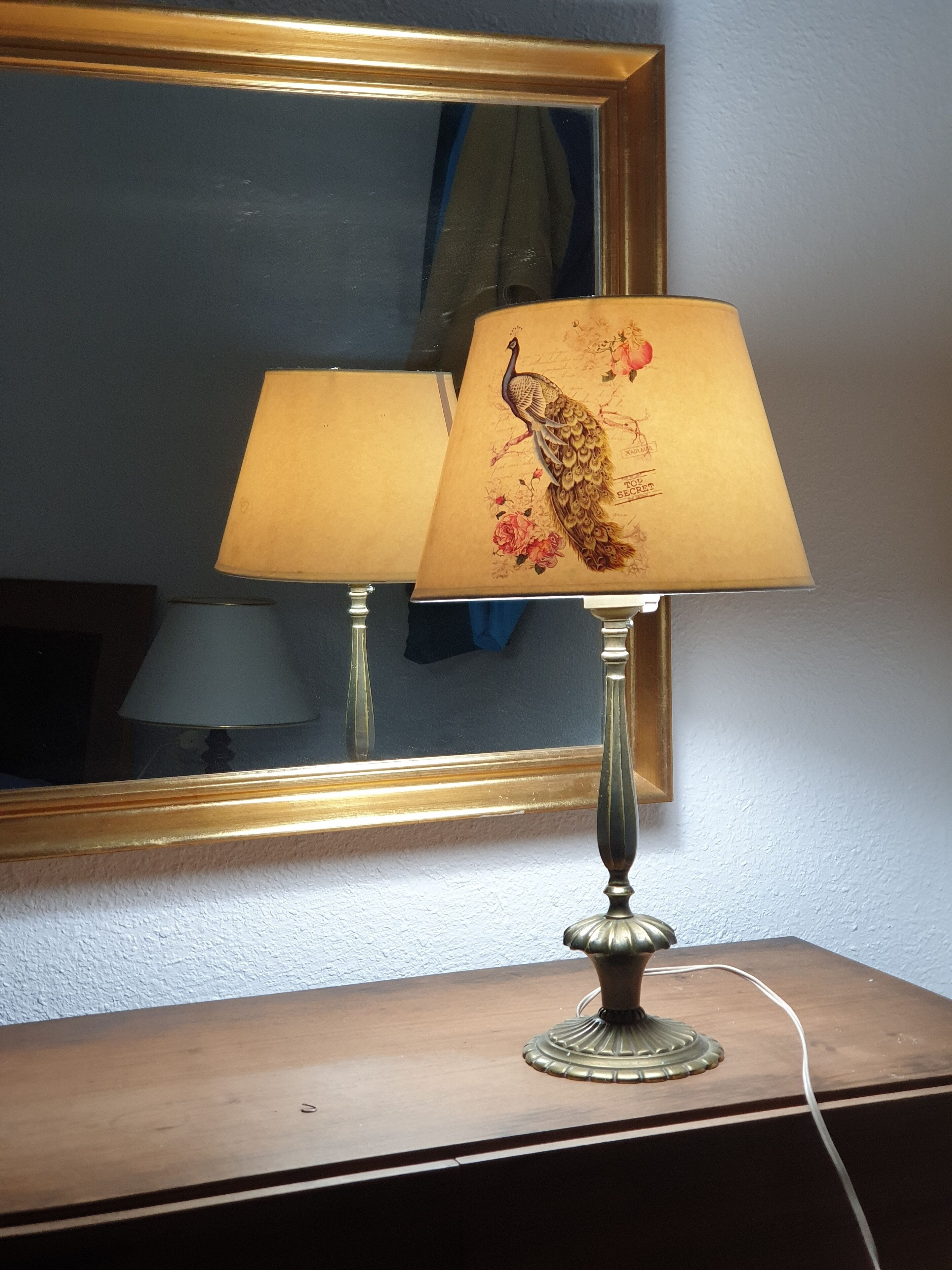 A lamp with a floral design on a wooden table.
