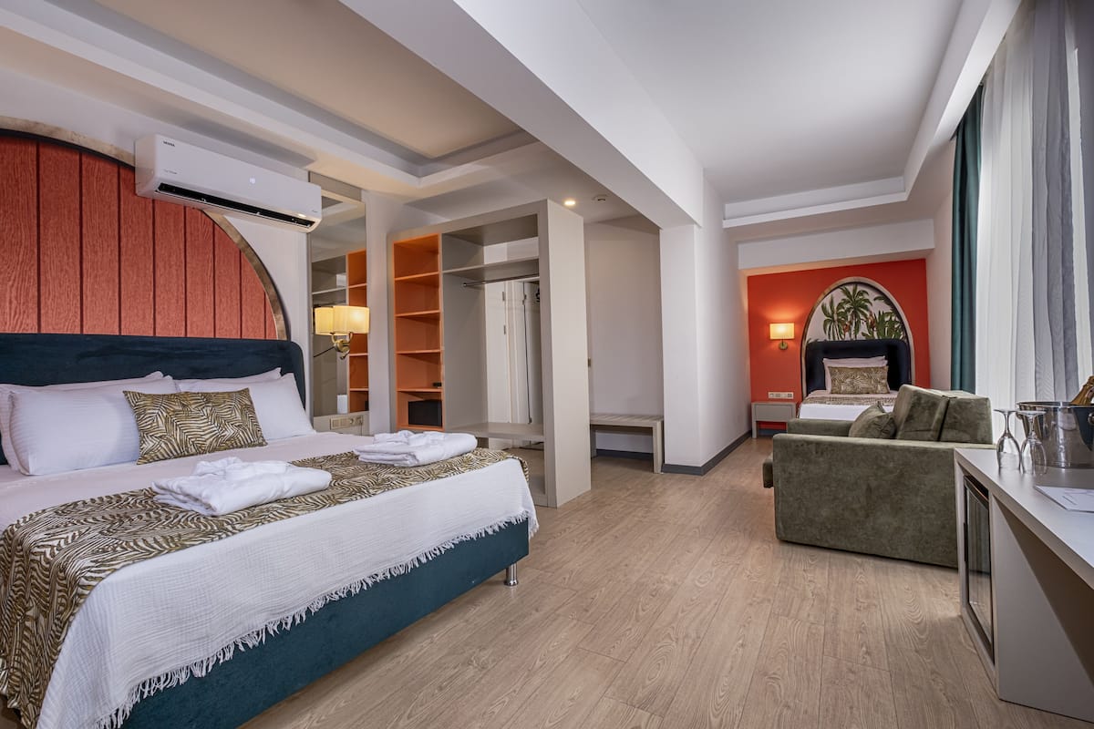 Una habitación de hotel moderna con una cama grande, un área de estar y un vestidor.