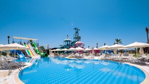 Een groot zwembad met meerdere glijbanen en een waterpark.