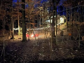 Escape to a secluded cabin surrounded by forested tranquility, featuring a cozy atmosphere and a natural ambiance.