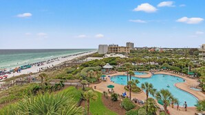 Een resort met een groot zwembad, toegang tot het strand en uitzicht op de oceaan.