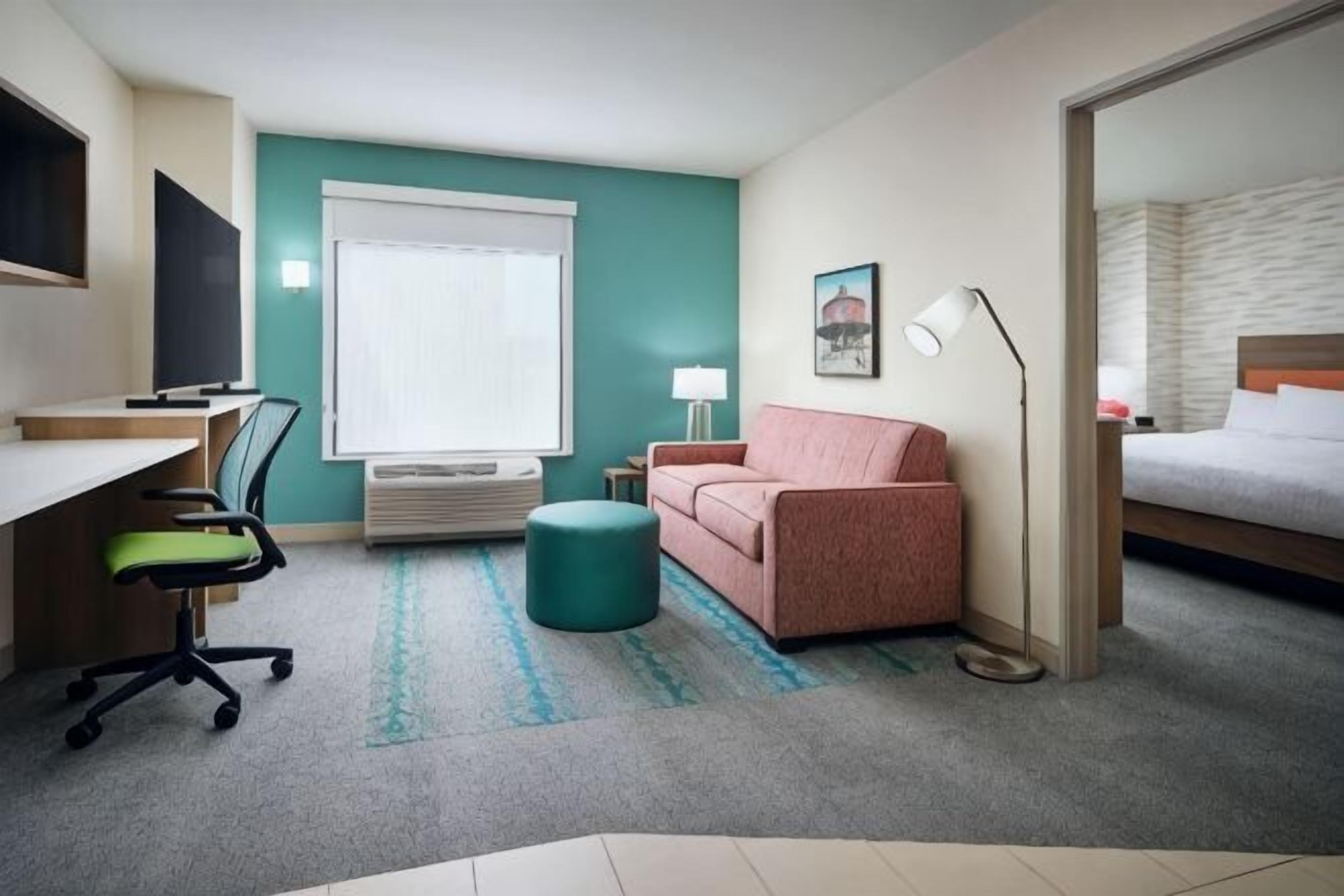 Escritorio, tabla de planchar con plancha y ropa de cama 