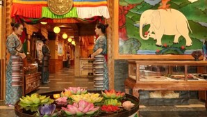 A traditional interior with a reception area, a decorative wall with an elephant painting, and a lotus pond. - Norbu Serwo Hotel (Xiahe)