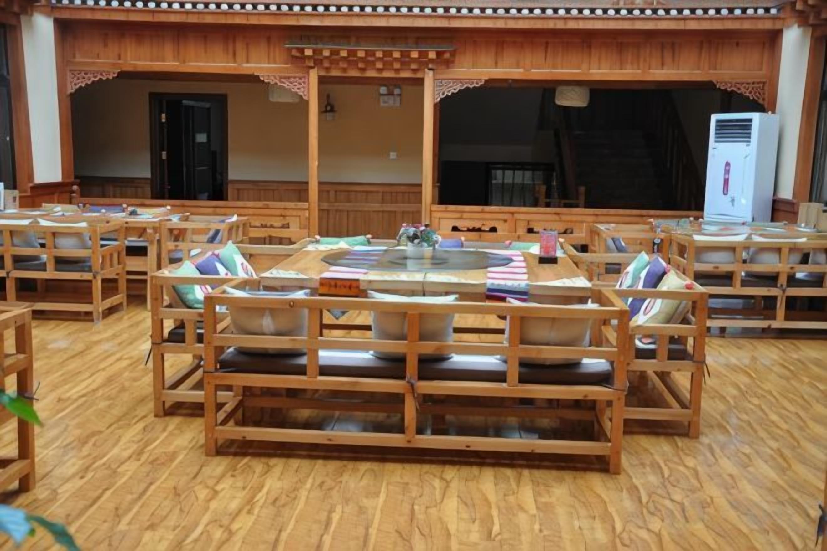 Un restaurant avec des meubles en bois et une grande table centrale.