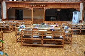 A restaurant with wooden furniture and a large central table.