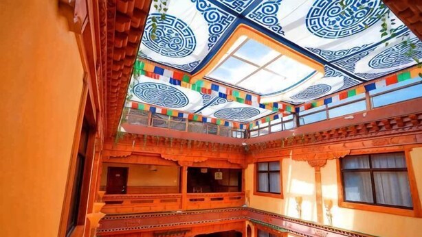 A traditional building with a multi-level structure, balconies, and a patterned ceiling. - Norbu Serwo Hotel (Xiahe)