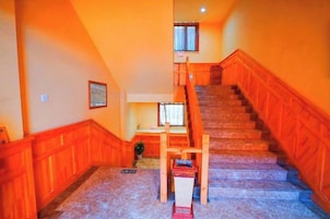 Una escalera con barandillas de madera y piso alfombrado.