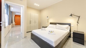 A modern hotel room with a large bed, bedside tables, a desk, and a wardrobe. - San Luca Apartments - Pallavicini by Wonderful Italy (Genoa)