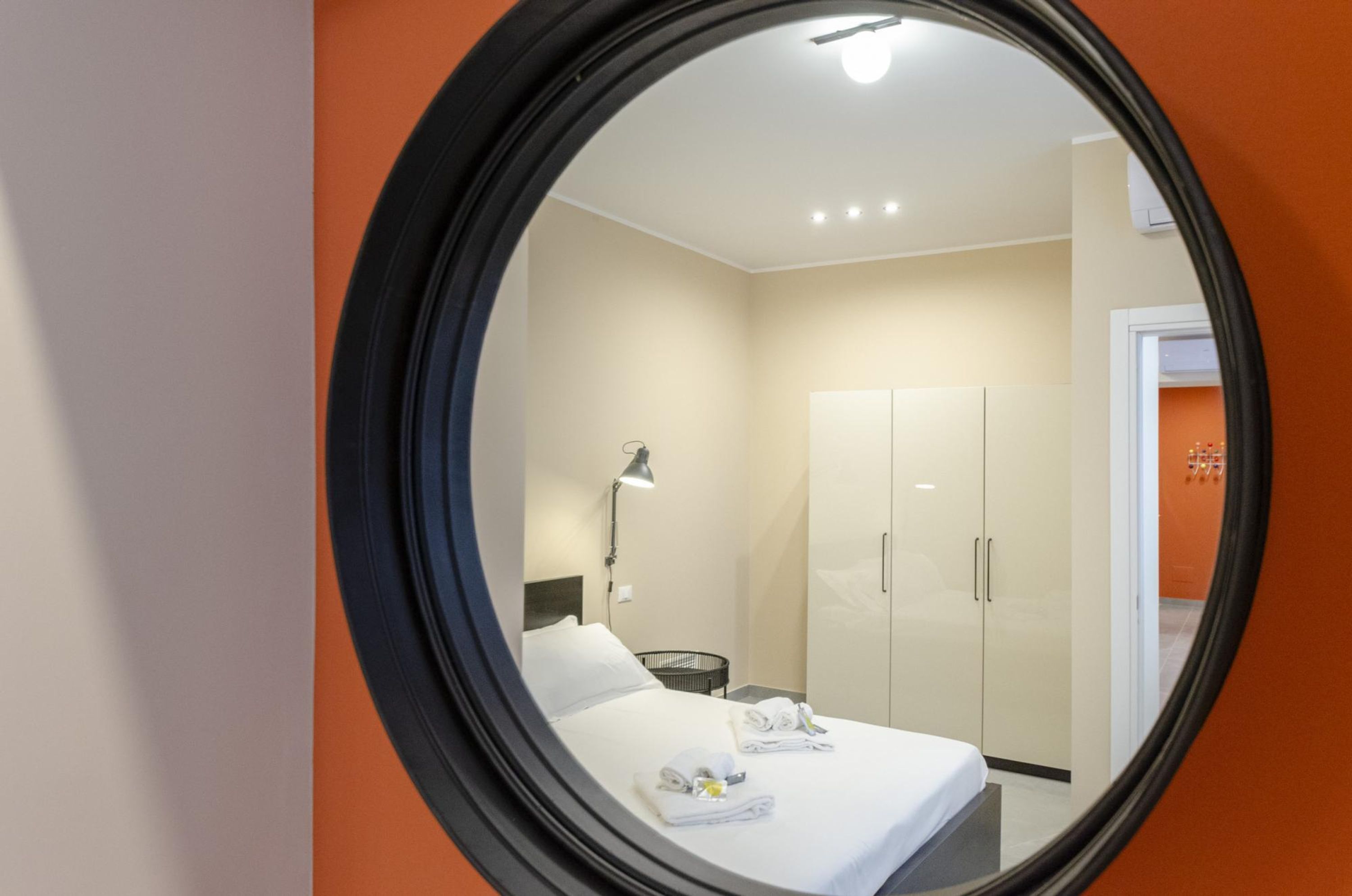 Ein Hotelzimmer mit Bett, Schreibtisch, Lampe und Kleiderschrank.