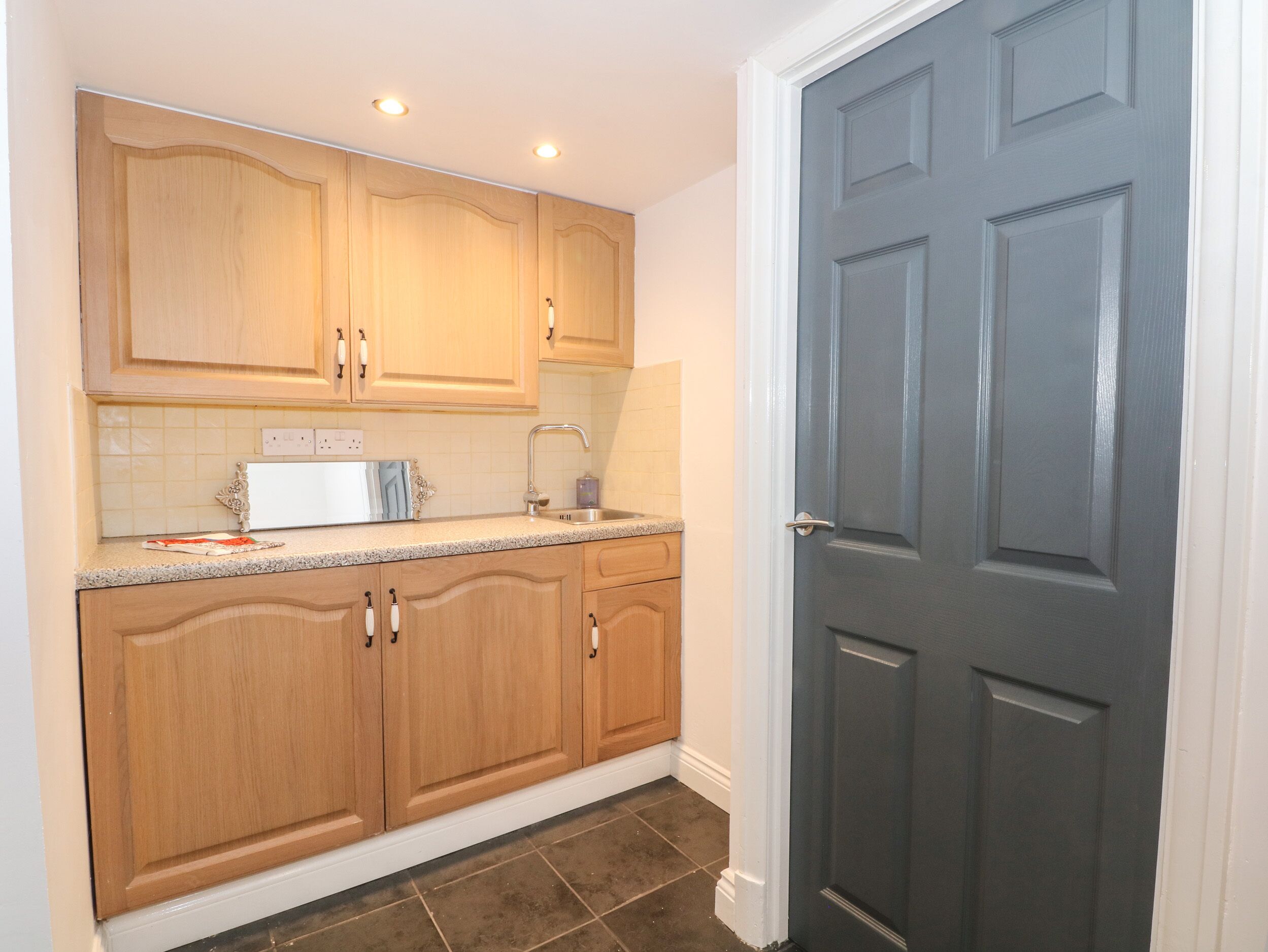 A kitchen with wooden cabinets, a sink, and a countertop.