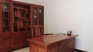 A wooden dining table with a cabinet and a chair. - Qingyunshan Jieyou Hostel (Yongtai)