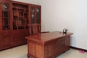 A wooden dining table with a cabinet and a chair. - Qingyunshan Jieyou Hostel (Yongtai)