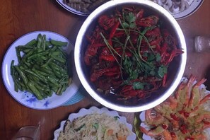Una mesa con diferentes platos, incluyendo un bol de pimientos rojos y verduras, y un plato que parece ser de fideos.