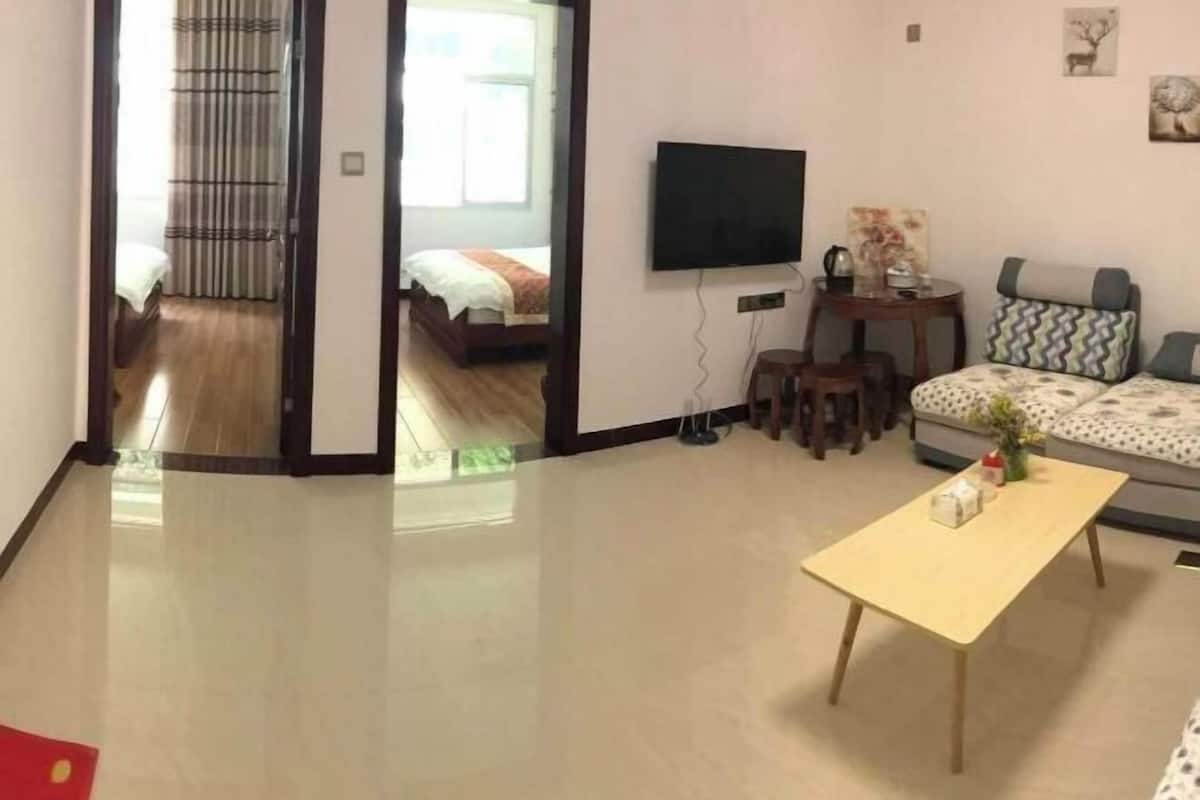 Una camera d'albergo moderna con un letto, una TV, un divano e un tavolino.