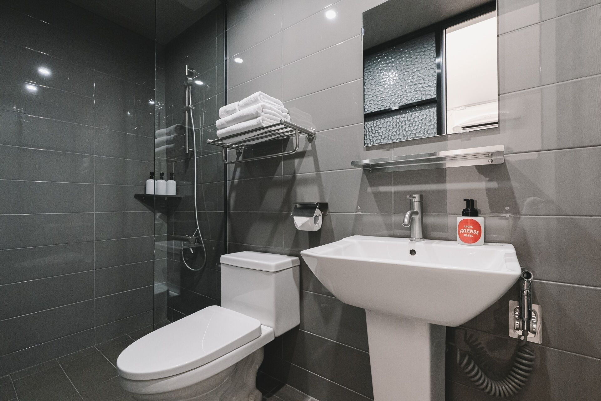 A modern bathroom with a toilet, sink, and shower.