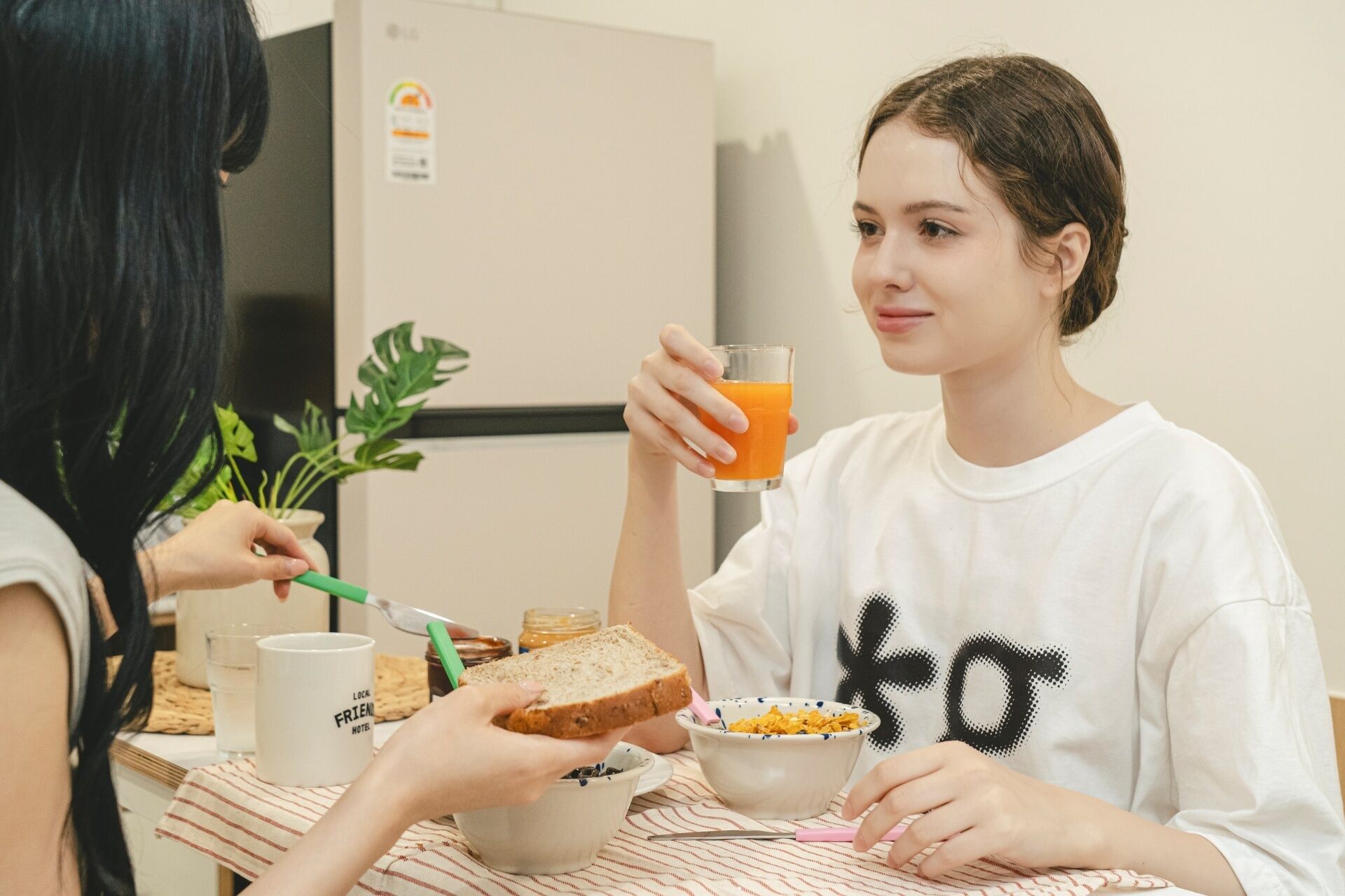 A breakfast scene with toast, cereal, and a glass of orange juice on a table.