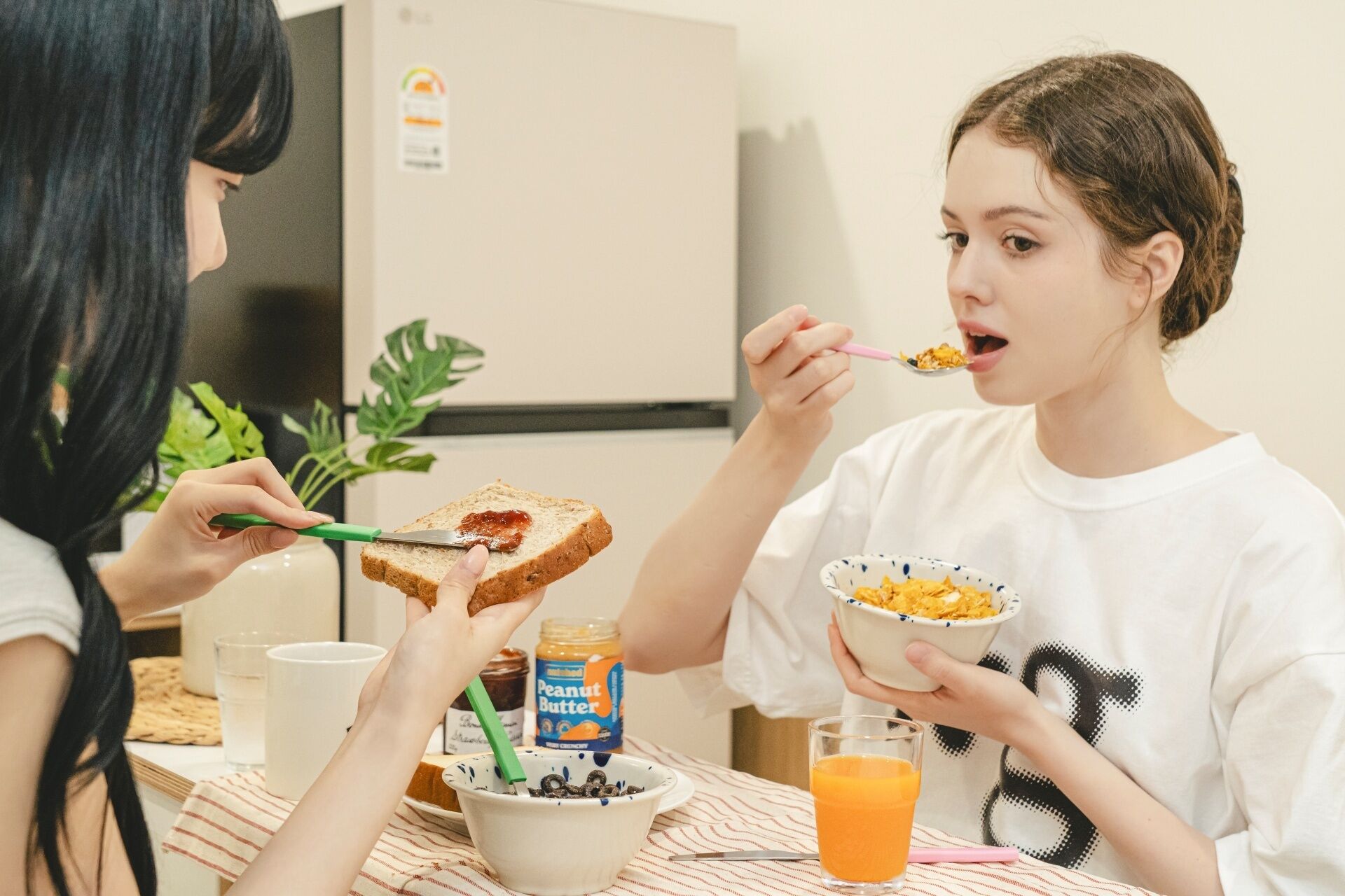 A breakfast scene with toast, cereal, and orange juice on a table.
