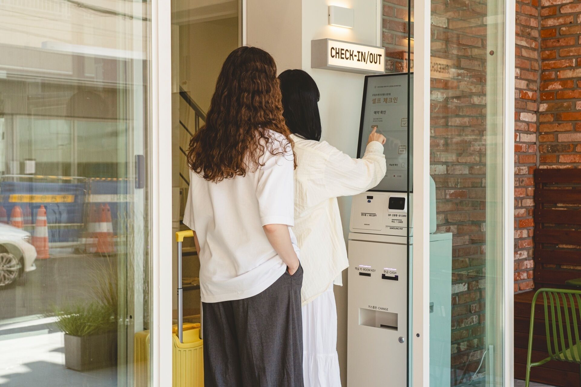 Une personne utilisant un terminal d’enregistrement/départ situé à l’entrée d’un hôtel.