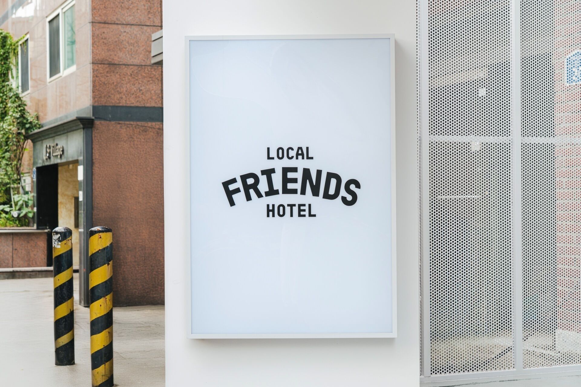 A framed sign with the text 'LOCAL FRIENDS HOTEL' on a white background.
