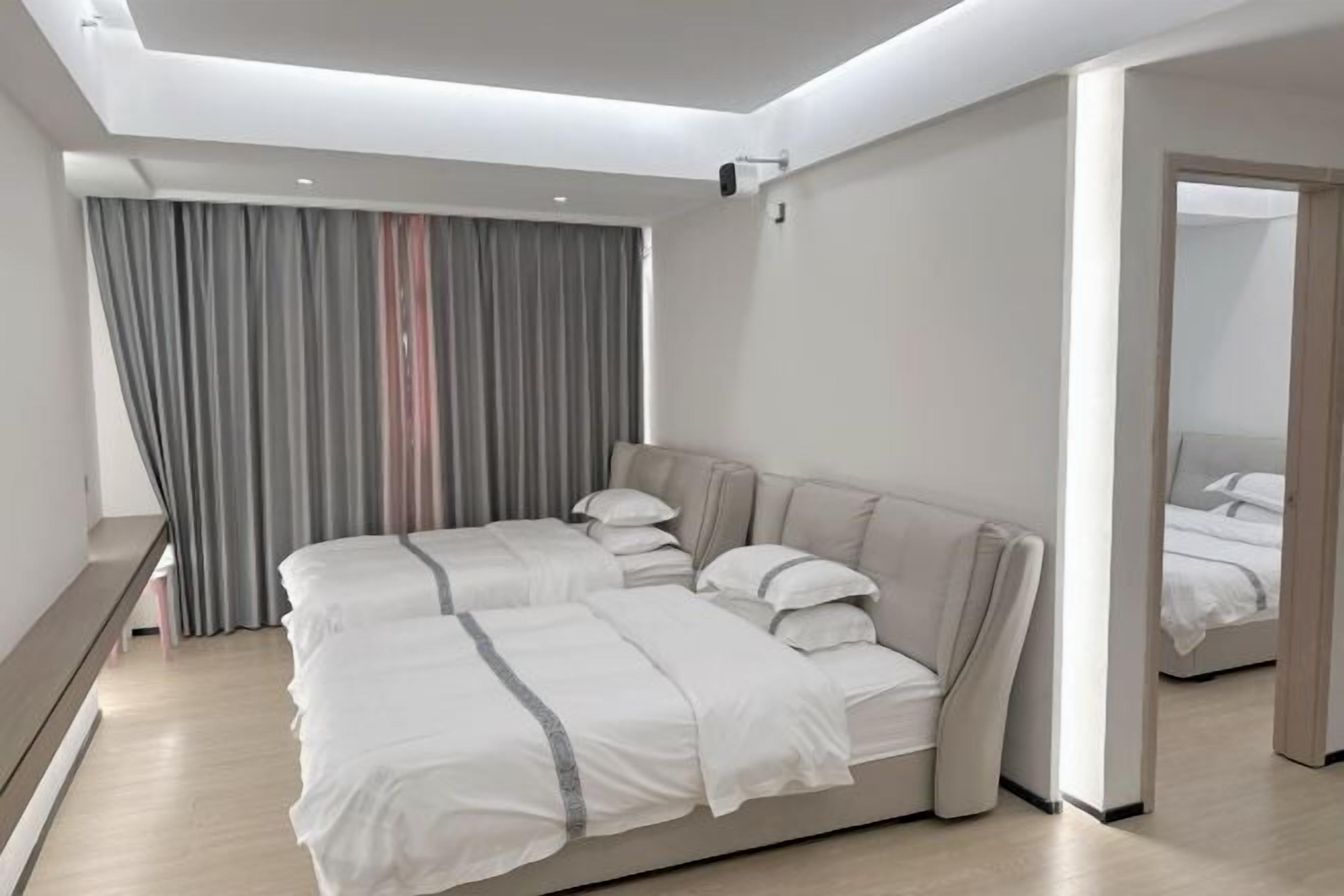 Ein modernes Hotelzimmer mit einem großen Bett, einem Schreibtisch und Blick auf die Stadt.
