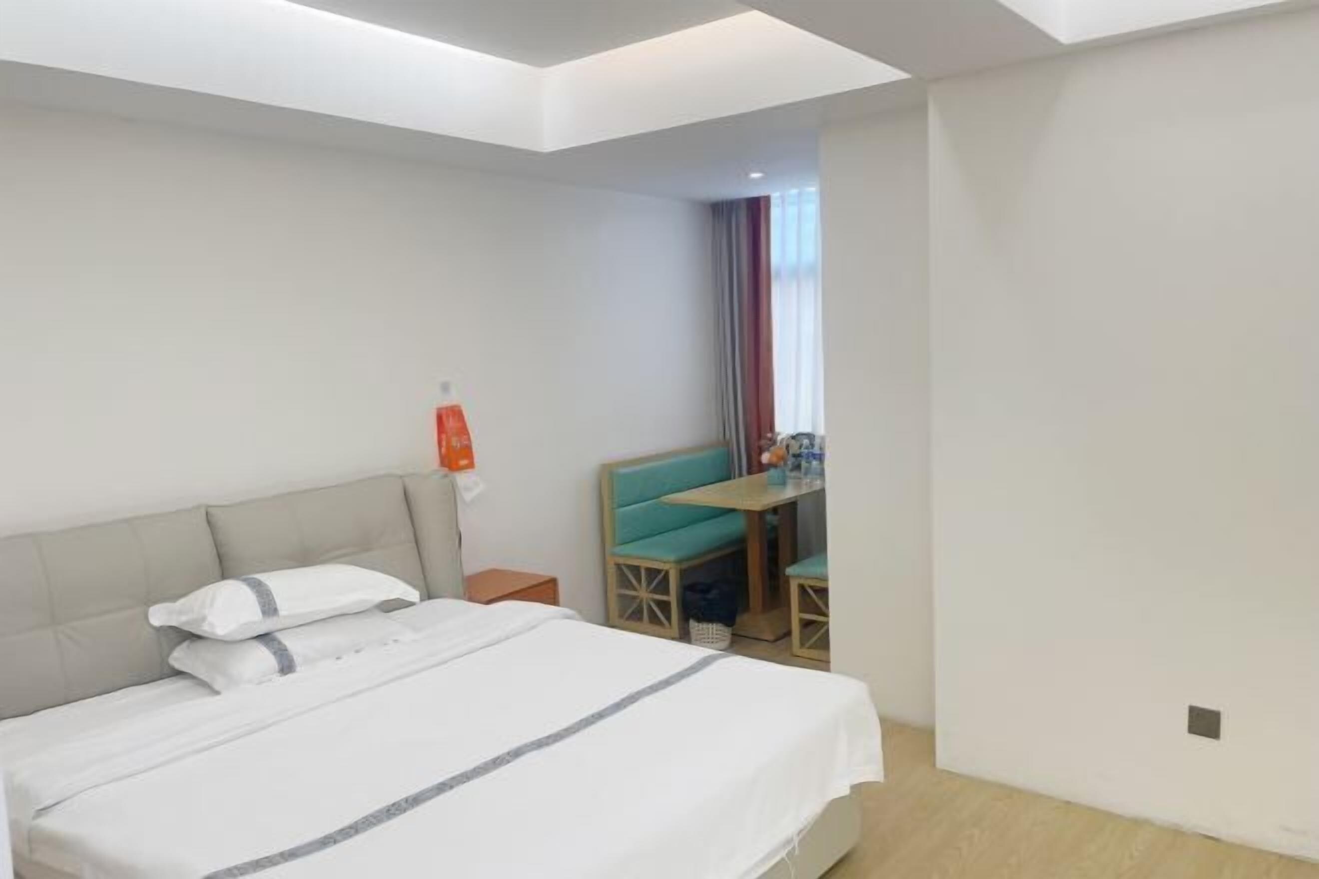 A hotel room with a bed, a desk, and a chair.