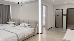 A modern hotel room with a large bed, a desk, and a walk-in closet. - Jixing Hostel (Shantou)