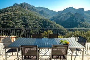 A terrace with a table and chairs, overlooking a mountainous landscape. - Luxury Villa 8w/ Pool, Sea &amp; Mountain Views (Fréjus)