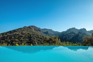 Une vue dégagée sur une chaîne de montagnes, avec une piscine au premier plan.