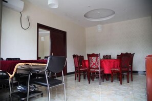 A conference room with a table and chairs, a door, and a ceiling light fixture. - Junlong Holiday Hotel (Dafang)