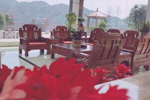 A dining area with wooden furniture and a view of mountains.