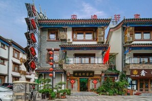 Un edificio tradizionale con diversi piani, balconi e un cartello con caratteri cinesi.