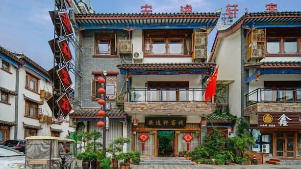 Un edificio tradicional con varios pisos, balcones y un letrero con caracteres chinos.