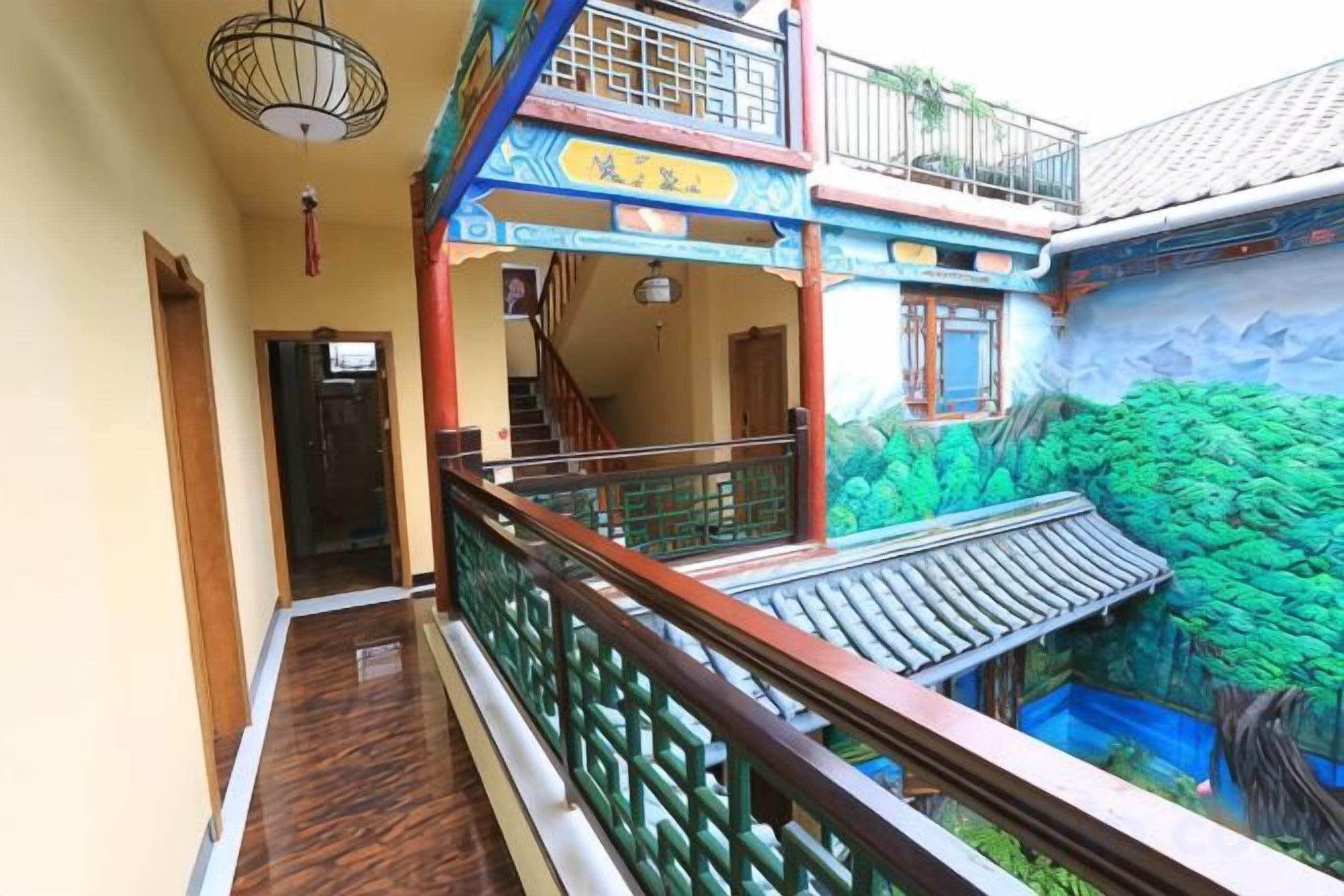 A corridor with a wooden floor, a balcony with a railing, and a mural of a forest scene.