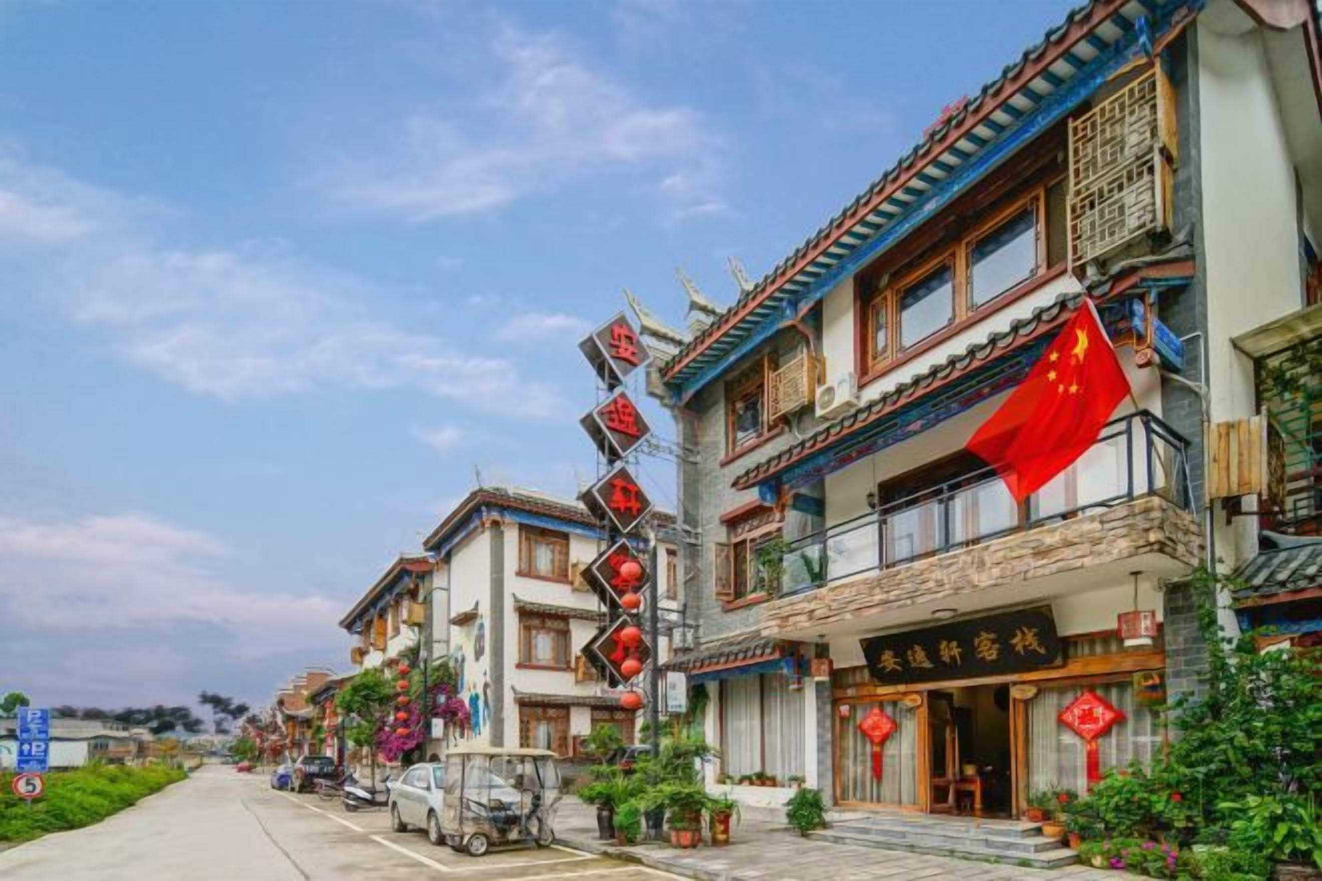 Un edificio tradicional con varios pisos, balcones y una bandera roja.