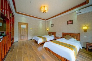 A hotel room with two beds, wooden flooring, a wooden wardrobe, and a door with a sign. - Anyixuan Inn (Libo)
