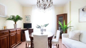 A dining area with a chandelier, a dining table, chairs, a sofa, and a television. - OMAR'S HOUSE - Affitti Brevi Italia (Rapallo)