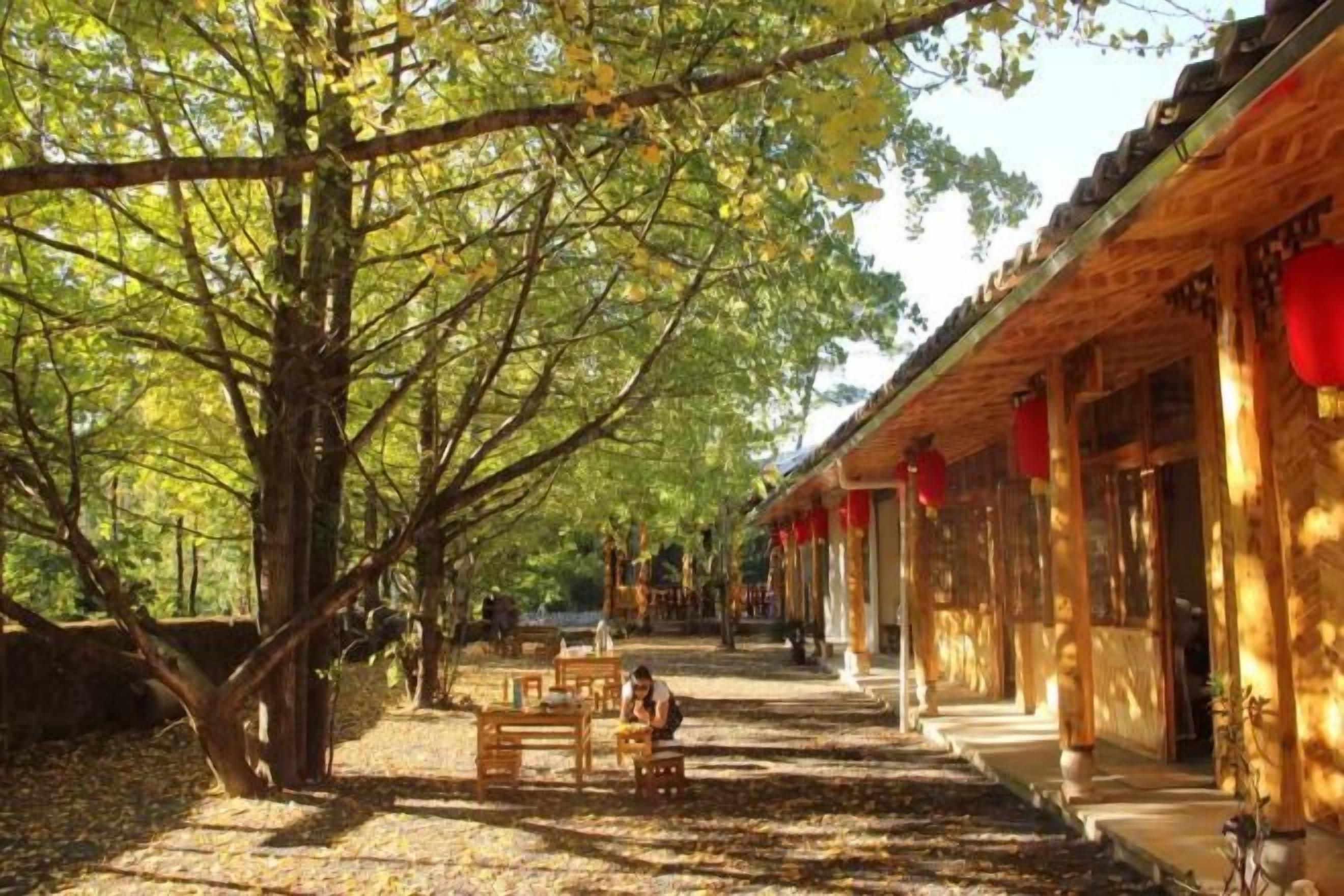 A traditional building with a covered walkway, wooden benches, and red lanterns.