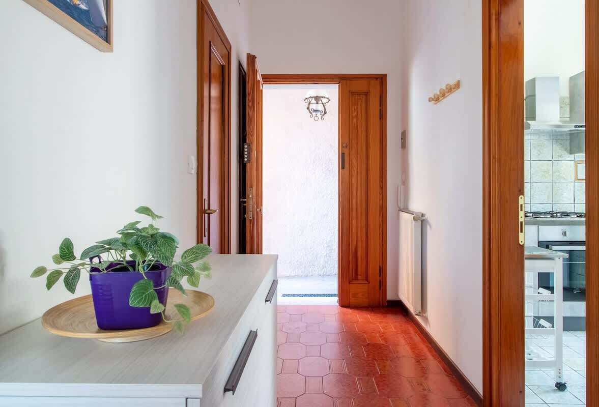 Un couloir avec une porte en bois donnant sur un espace cuisine.