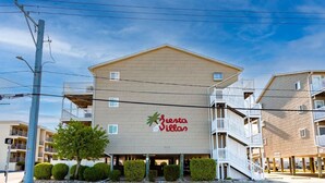 Ein mehrstöckiges Hotel mit einem Schild, auf dem 'Gente Villas' steht.
