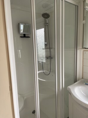 A glass-enclosed shower with a handheld showerhead and a wall-mounted faucet. - Immaculate 2-bed Static Caravan at Monrieth (Newton Stewart)