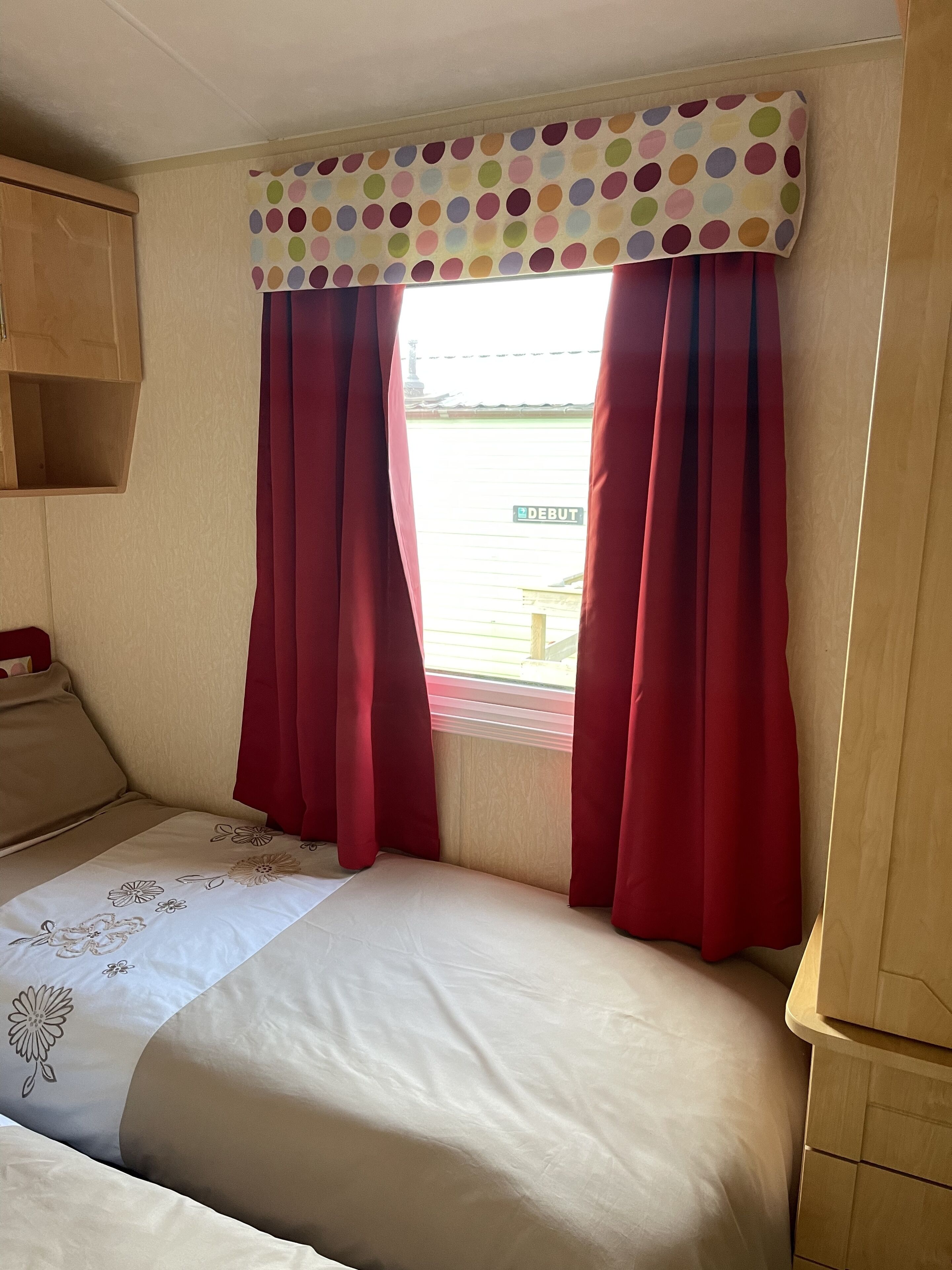 Une chambre à coucher avec un lit, des rideaux et une fenêtre donnant sur un immeuble.