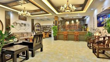 A spacious lobby with a reception desk, seating area, and decorative lighting.